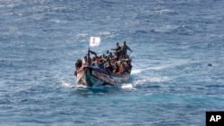 FILE - Migrants crowd a wooden boat as they sail to the port in La Restinga on the Canary island of El Hierro, Spain, on Aug. 18, 2024.