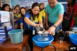 คาร์ลิโต เซอร์นัล ตรวจสอบผลงานจับเป็นไข่ยุงของชาวบ้านที่มอบให้ทางการ ตามโครงการ "เปโซแลกยุง" ในกรุงมะนิลา 19 ก.พ. 2025