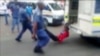 A South African man with his hands tethered to the back of a police vehicle being dragged behind as police hold his legs up and the vehicle apparently drives off, east of Johannesburg, Feb. 26, 2013. The man died of his injuries.