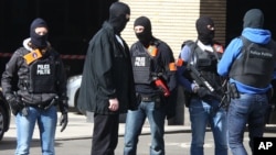 Hooded Belgian police officers patrol outside the Gare du Midi train station in Brussels, March 22, 2016. 