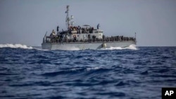 FILE - A photo released by the Libyan Coast Guard shows a ship with migrants off the coast of Libya, June 24, 2018.