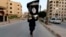 A member loyal to the Islamic State in Iraq and the Levant waves an ISIL flag in Raqqa, Iraq, June 29, 2014.