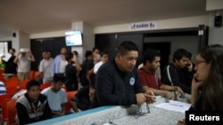 FILE - People deported from the U.S. wait to make a phone call to the U.S. at an immigration facility in San Salvador, El Salvador, July 3, 2018.
