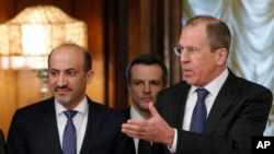 Russian foreign minister Sergey Lavrov, right, welcomes Ahmad Jarba, left, who heads a delegation of the Syrian National Coalition prior talks in Moscow, Feb. 4, 2014.