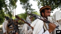Taliban fighters, seen in this 2011 file photo, hold their heavy and light weapons before surrendering them to Afghan authorities in Jalalabad, east of Kabul, Afghanistan.