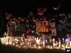 In this May 3, 2016 photo, candles burn at a makeshift memorial for Ashlynne Mike on the Navajo Nation southwest of Farmington, N.M. The FBI said Mike, was abducted after school on Monday, May 2, and her body was found the next day.