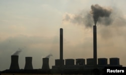 FILE - Smoke rises from the Duvha coal-based power station owned by state power utility Eskom, in Mpumalanga province, South Africa, Feb. 18, 2020.