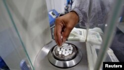 印度一家医药公司的雇员在称普通止痛药扑热息痛药片的重量。（2020年3月4日）