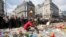 A woman lays flowers on a memorial to victims of the Brussels attacks during a march against hate in Brussels on Sunday, April 17, 2016.