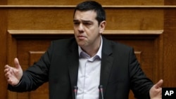 Greek Prime Minister Alexis Tsipras speaks in parliament before the vote of an anti-poverty bill, the first piece of legislation from the left-wing government, in Athens, March 18, 2015.