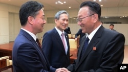 FILE - North Korea's Kim Yang Gon, right, speaks with South Korean Unification Minister Hong Yong-pyo, left, after their meeting at the border village of Panmunjom in Paju, South Korea, Aug. 25, 2015. 