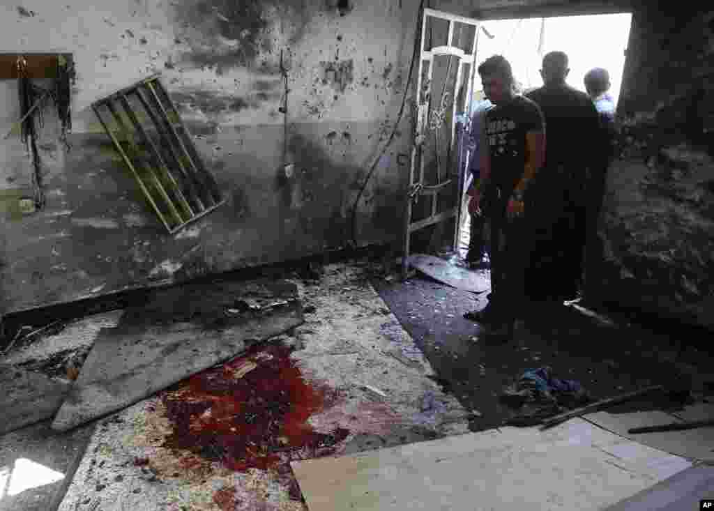Worshipers view the damage to the inside of the Imam Ali mosque after a suicide bomb attack in New Baghdad, Aug. 25, 2014.