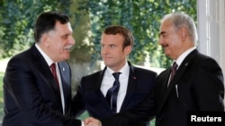 Le chef du Gouvernement d’Union Nationale Fayez al-Sarraj et le général Khalifa Haftar, commandant de l'armée nationale libyenne, réunis autour du président Français,Emmanuel Macron,près de Paris le 25 juillet 2017. REUTERS / Philippe Wojazer / Photo D’ARCHIVES