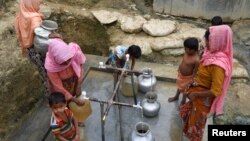 FILE - Rohingya refugees collect drinking water at the Shalbagan refugee camp in Teknaf, Bangladesh, March 5, 2019.
