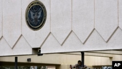 In this Thursday, Sept. 18, 2008 file photo, a worker repairs the damaged gate of the main entrance of the US embassy in the capital Sanaa, Yemen. 