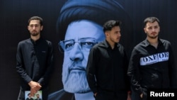 Mourners attend a burial ceremony of the late Iran's President Ebrahim Raisi in Mashhad