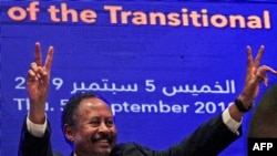 Sudanese Prime Minister Abdalla Hamdok flashes the victory gesture during a press conference unveiling the first cabinet since veteran leader Omar al-Bashir's overthrow, in Khartoum, Sept. 5, 2019. 