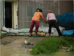 Two women put stack sandbags to keep rising waters from flooding their house in Spean Tmor commune, Dangkoa district, Phnom Penh, Cambodia, on Oct. 14, 2020. (Malis Tum/VOA Khmer)