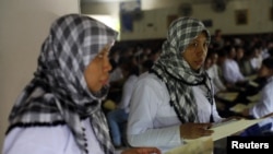A Indonesian migrant worker heading for Middle East countries holds her passport documents at an immigration office. 