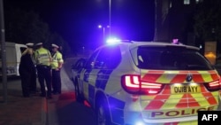 Police officers are seen at a police cordon in central Reading, west of London, on June 20, 2020, following a stabbing at Forbury Gardens park.