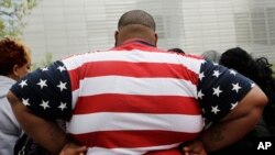 In this Thursday, May 8, 2014 photo, a man wears a shirt patterned after the American flag during a visit to the World Trade Center, in New York. 