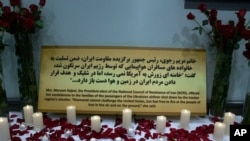 File - Candles and flowers are displayed with condolences offered to the families of the passengers of the Ukrainian jetliner shot down by Iran by accident at a memorial at the Los Angeles Convention Center Saturday, Jan. 11, 2020.