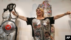 In this July 10, 2014 photo, a woman strikes a power pose after putting on a piece of wearable art by Linda Stein. This piece has a Wonder Woman theme designed to give the wearer a sense of empowerment.(FILE PHOTO)
