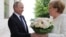 Russian President Vladimir Putin welcomes German Chancellor Angela Merkel during their meeting in the Black Sea resort of Sochi, Russia, May 18, 2018. 