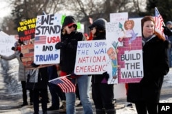 Supporters hold signs at a Women for Trump "Build the Wall" rally in Bloomfield Hills, Mich., Jan. 26, 2019.