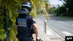 A municipal police officer keeps watch near a traffic circle in Noumea, New Caledonia, on May 15, 2024, amid protests linked to a debate on a constitutional bill under debate in the French parliament.