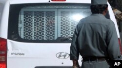 FILE - Fingers of an man sentenced to death are seen through a vehicle's rear window at a jail in Kabul, Afghanistan, Oct. 8, 2014. Afghan President Ashraf Ghani promised to expedite the execution process for insurgents sentenced to death.
