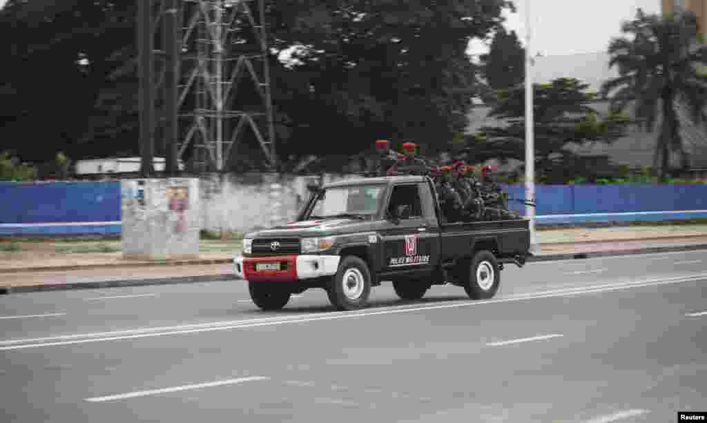 Congolese soldiers ride on their pick-up truck towards the state television headquarters in Kinshasa, Dec. 30, 2013.