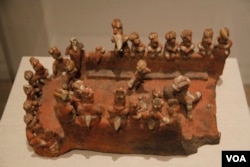 The ball court model, from Mexico's Nayarit culture (200 B.C.-A.D. 500), features an eye-shaped ball court with markers on it, plus the players. "We think the game probably was a little like soccer," curator Joanne Pillsbury says.
