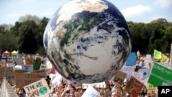 FILE - A large inflatable globe is bounced through the crowd as thousands of protestors, many of them school students, gather in Sydney, Friday, Sept. 20, 2019, calling for action to guard against climate change. 