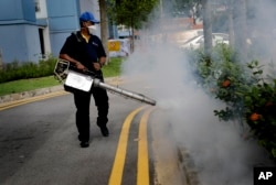 A pest control worker fumigates drains at a local housing development where Zika infections were reported in Singapore, Sept. 1, 2016.