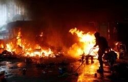 A protester attempts to extinguish a fire at the campus of Hong Kong Polytechnic University (PolyU) during clashes with police in Hong Kong, China, November 18, 2019.
