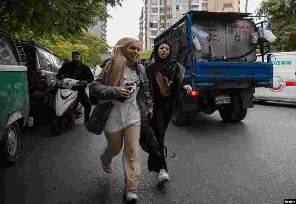 Girls react as they run for cover after an Israeli strike on a building, that according to security sources killed Hezbollah's media relations chief Mohammad Afif, in Ras Al- Nabaa, Beirut, Lebanon.