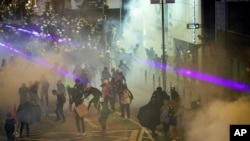 Protesters react from tear gas fired by riot policemen during the anti-extradition bill protest at Causeway Bay in Hong Kong, Aug. 4, 2019.