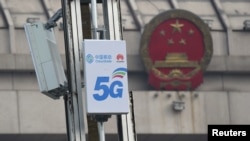 Antena jaringan 5G dengan logo China Mobile dan Huwaei terpasang di depan gedung Kongres Rakyat Nasional di Luoyang, Provinsi Henan, China, 27 Februari 2019. 