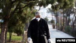 An Iranian man wears a protective mask against the coronavirus as he walks on a street in Tehran, Iran February 29, 2020.