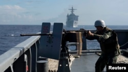 FILE - The Philippine Navy is upgrading its fleet amid growing maritime disputes. Here, one of its troops fires a .50-caliber machine gun during a bilateral maritime exercise between the Philippine Navy and U.S. Navy in the South China Sea, June 29, 2014.