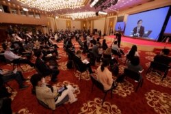 Journalists attend a news conference by Zhang Yesui, a spokesman for the National People's Congress, broadcast remotely to the media center on the eve of the annual legislature opening session in Beijing, May 21, 2020.