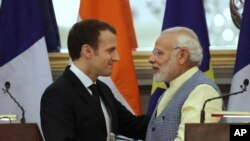 Perdana Menteri India Narendra Modi (kanan) berbincang dengan Presiden Perancis Emmanuel Macron seusai penandatangan kerjasama kedua negara di New Delhi, India, 10 Maret 2018.