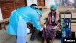 Volunteer checks the blood oxygen level of a coronavirus disease (COVID-19) patient in the town of Kale, Sagaing Region, Myanmar, July 5, 2021.