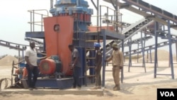 Workers examine new machinery in use at the pioneering mega-farm at Boukanga Lonzo park in Democratic Republic of Congo, Aug 8, 2015. (N. Long / VOA)