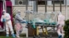 Un patient dans une unité de bioconfinement est transporté sur une civière depuis une ambulance arrivée à l'hôpital Columbus Covid 2 à Rome (Italie), le 17 mars 2020. (Photo: AP)
