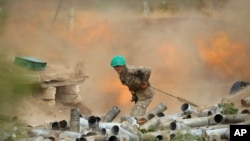 An Armenian serviceman fires a cannon toward Azerbaijan positions in the self-proclaimed Republic of Nagorno-Karabakh, Azerbaijan, Sept. 29, 2020. (Armenian Defense Ministry Press Service/PAN Photo via AP)