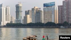 资料照：2013年12月7日，广东省广州市，一对夫妇沿着珠江(或珠江)附近的办公楼钓鱼。（路透社）