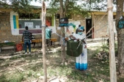 A woman casts her ballot at a polling station during Tigray’s regional elections, in the town of Tikul, 15 kms east from Mekele, Ethiopia, Sept. 9, 2020.