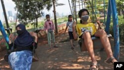Anak-anak perempuan dengan memakai masker, bermain ayunan di tengah pandemi di Jakarta (foto: ilustrasi). 